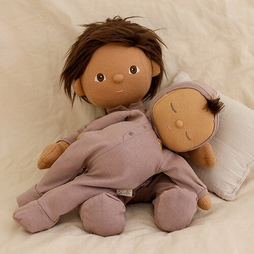 Twee Olli Ella lappenpoppen, een Dozy Dinkum Doll Pip en een grotere Dinkum Doll, liggen samen op een bed.