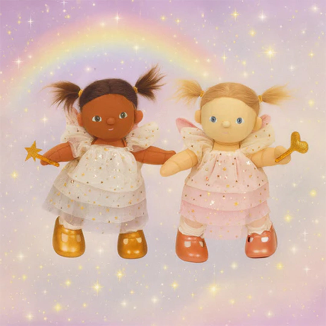 Twee Olli Ella lappenpoppen Dream Dinkum Dolls, een donkere en een lichte, beide als feeën met vleugels en toverstafjes voor een regenboogachtergrond.