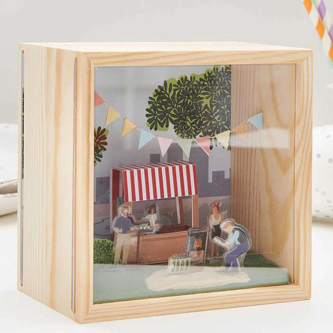 Houten objectdoos met een diorama van een marktscène met figuren.