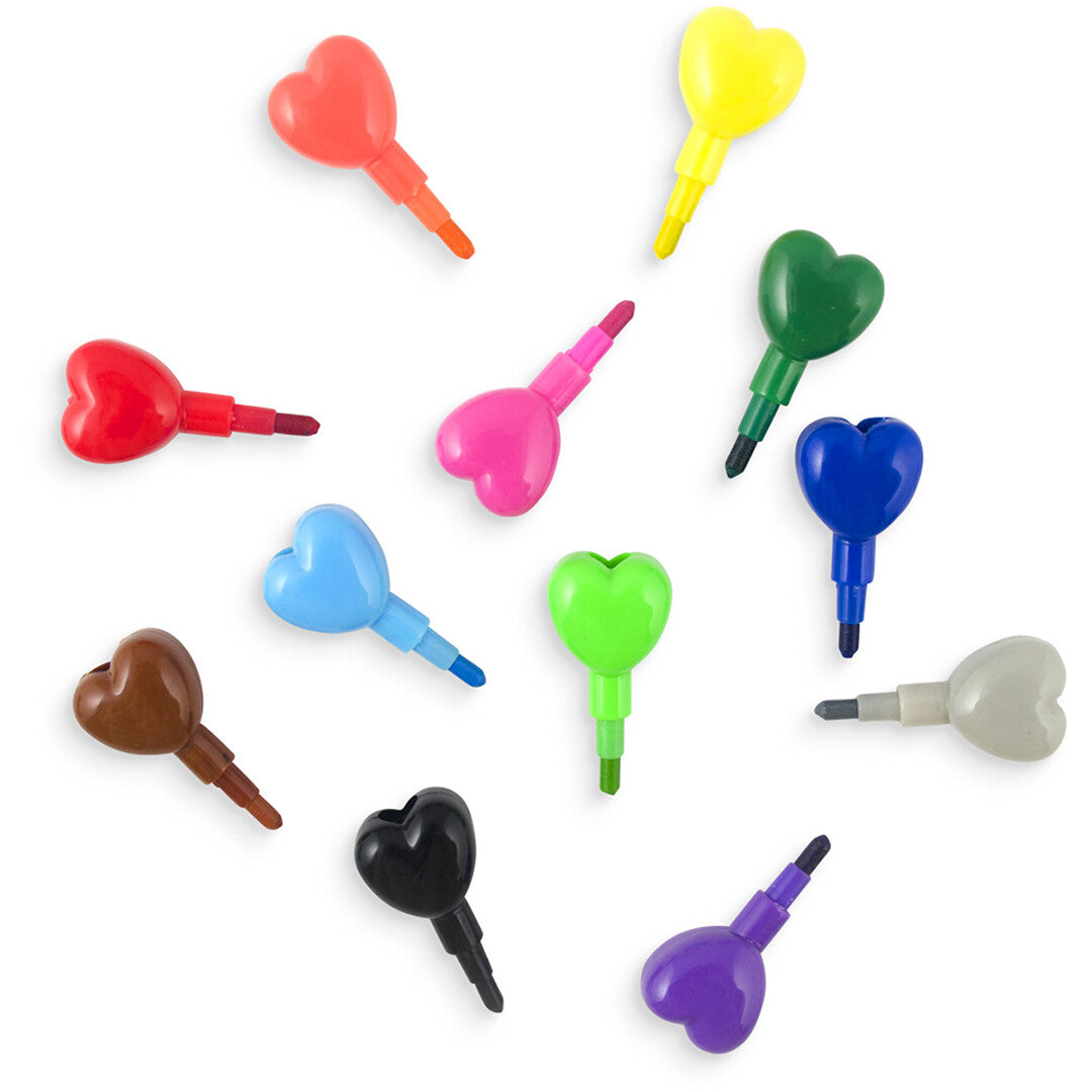 Ooly stapelbare hartjes krijtjes in verschillende kleuren, verspreid over een witte achtergrond.