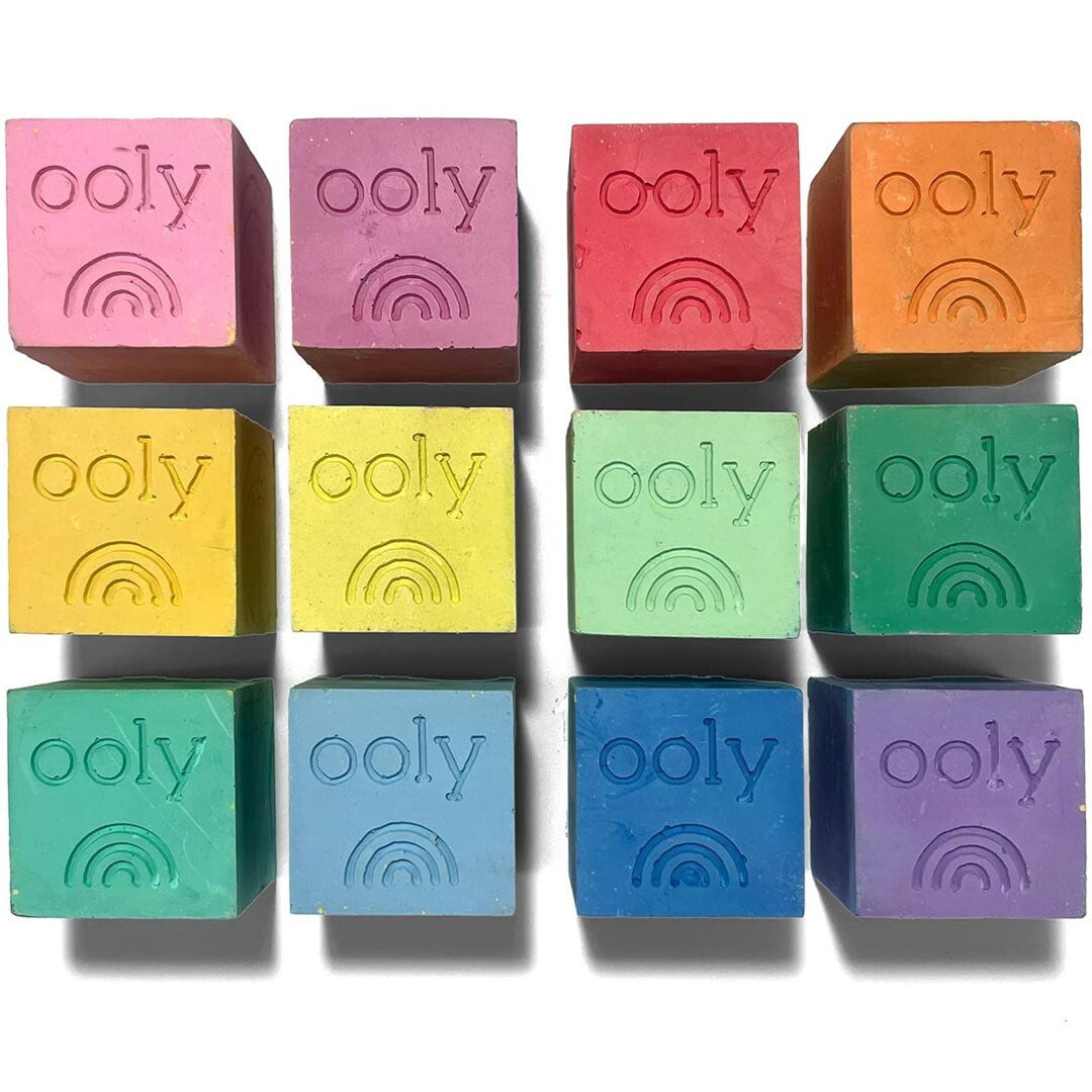 Twaalf Ooly blokken stoepkrijt in verschillende felle kleuren, elk met een regenboog en het merklogo erop.
