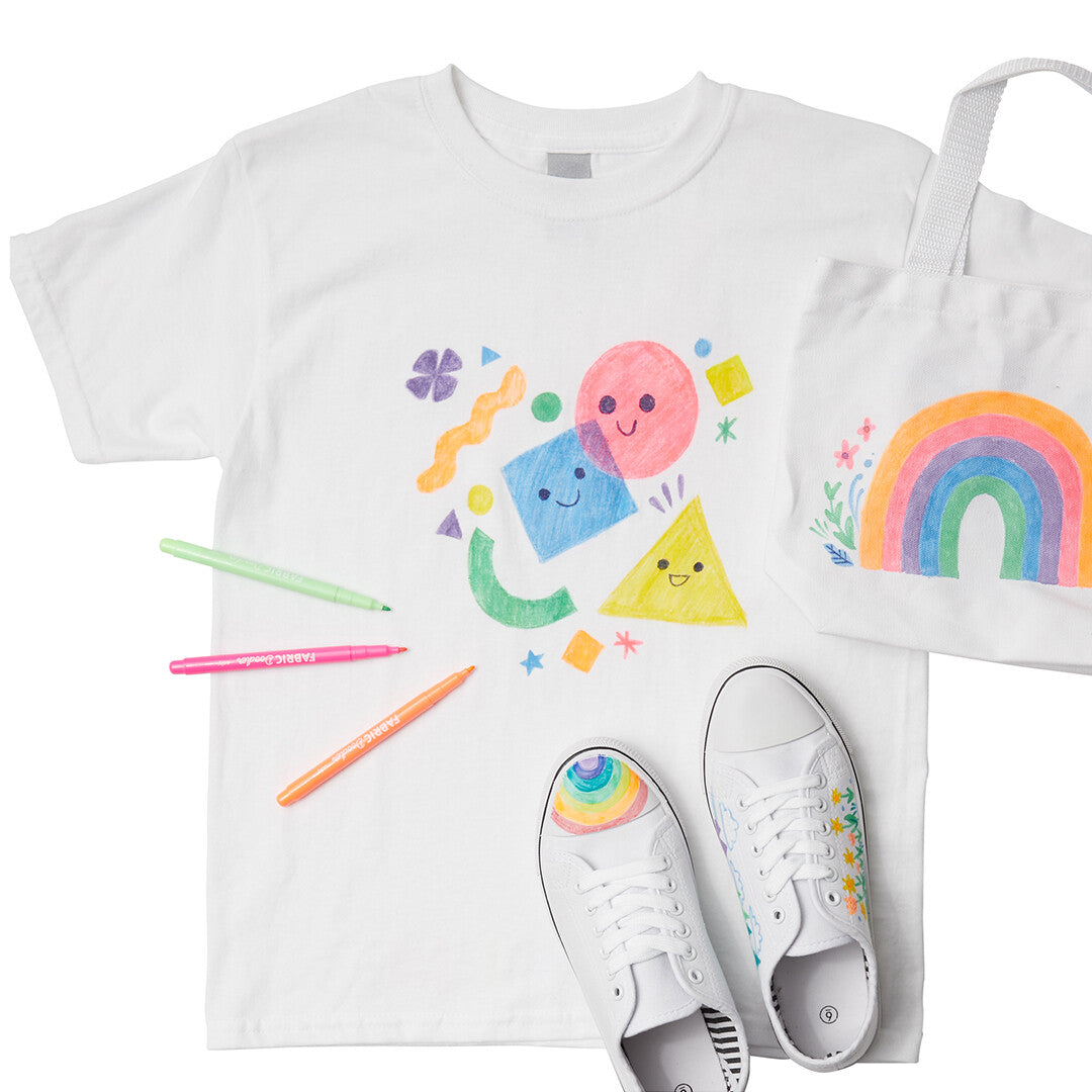 Een wit T-shirt, een tas en sneakers versierd met kleurrijke ontwerpen gemaakt met ooly Fabric Doodlers textielstiften.