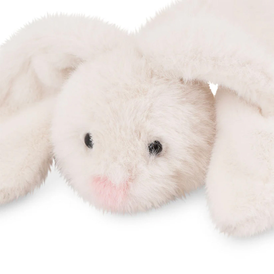 Detail van de kop van een wit pluchen knuffelkonijn met roze neus en zwarte ogen.