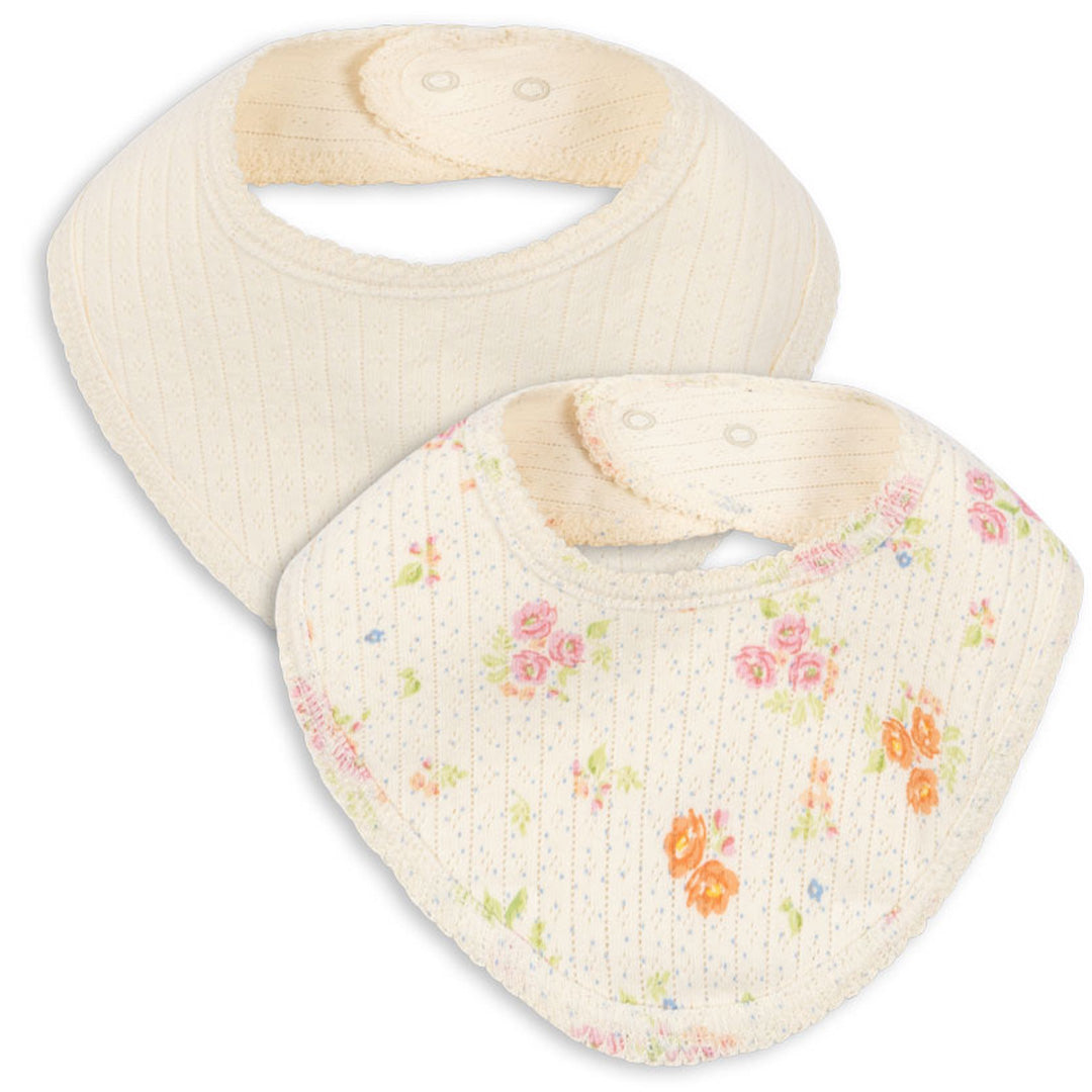 Twee Konges Sløjd babyslabjes, één effen beige en één beige met bloemenpatroon.