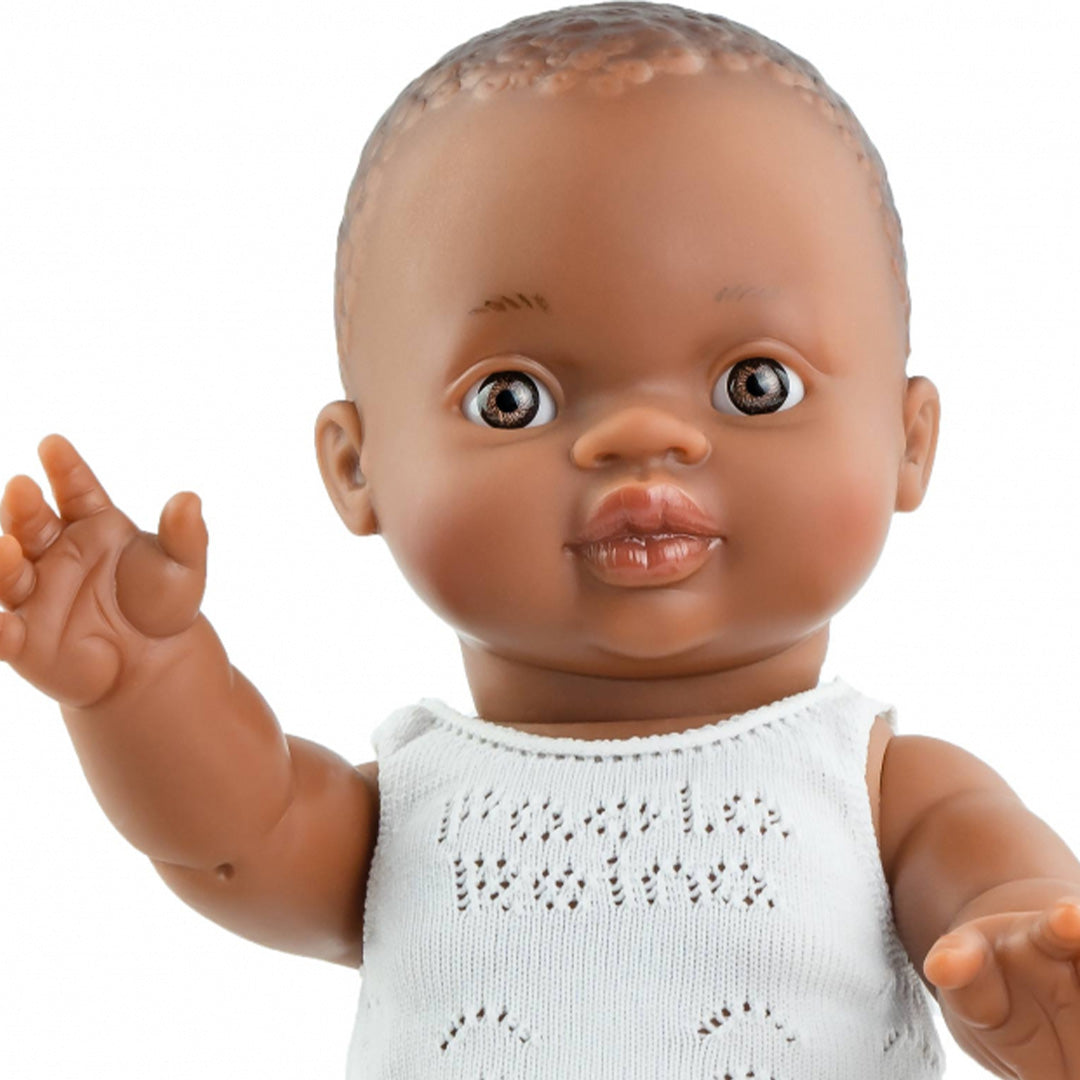 Close-up van het gezicht en bovenlichaam van de Paola Reina babypop Gordi jongen Bonifacio met donkere huidskleur en wit ondergoed.