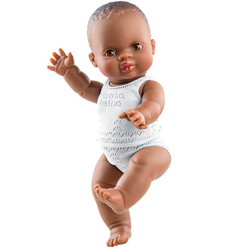 Paola Reina babypop Amparo met bruine huid en wit kanten ondergoed, staand afgebeeld.