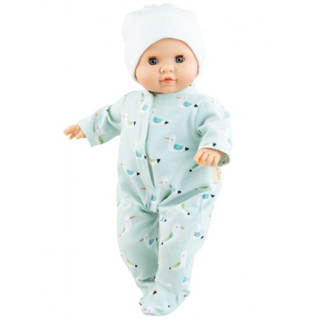 Paola Reina babypop Manus Martin in een lichtblauwe jumpsuit met vogelpatroon en een witte muts.