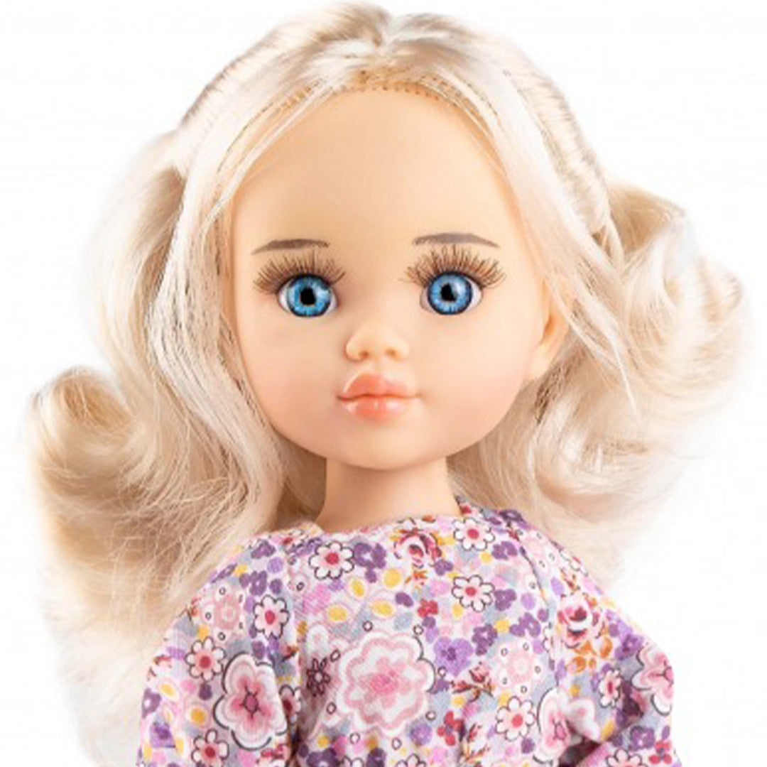 Detailfoto van de Paola Reina pop Clara met blonde krullen, blauwe ogen en een gebloemde jurk.