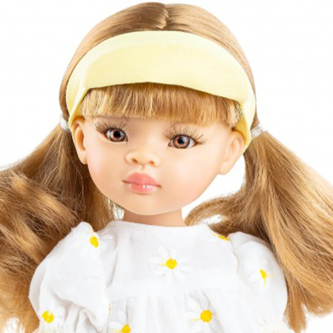 Detailfoto van het gezicht van pop Ksenia met bruine ogen en blonde vlechten.