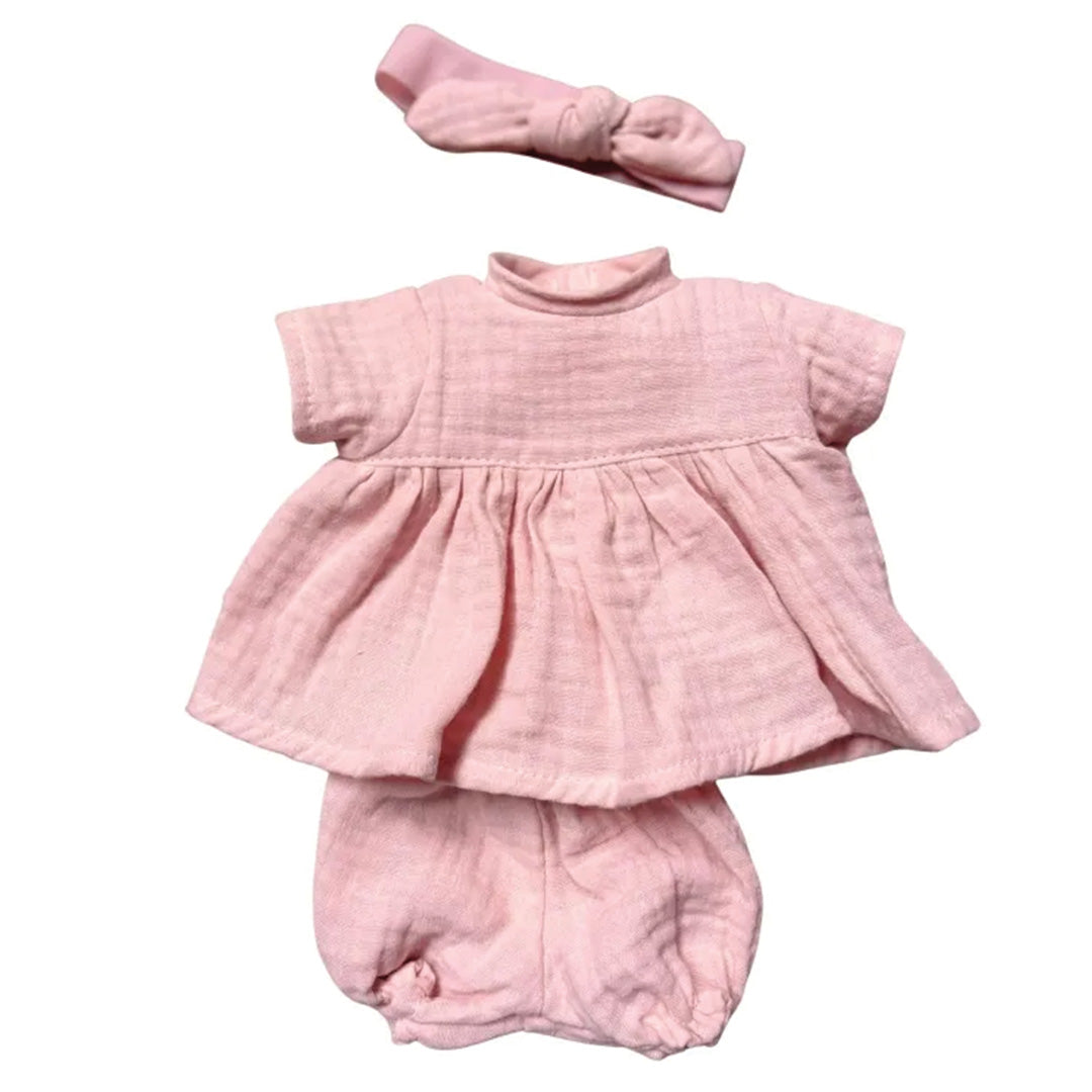 Roze poppenkleding set met top, broekje en hoofdband.