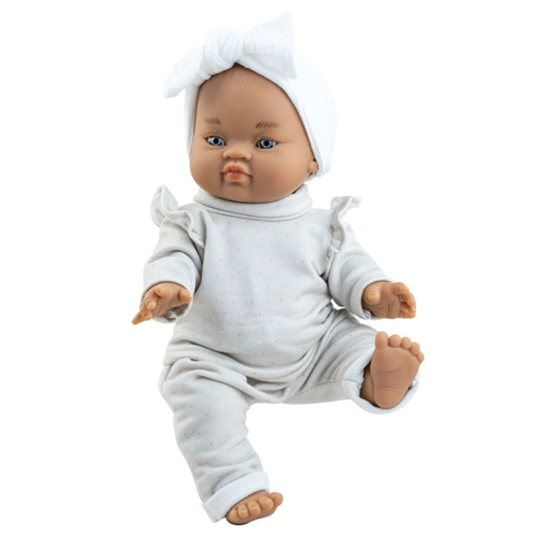 Paola Reina babypop Olga met donkere huid, blauwe ogen, witte stippeltjesoutfit en witte hoofdband.