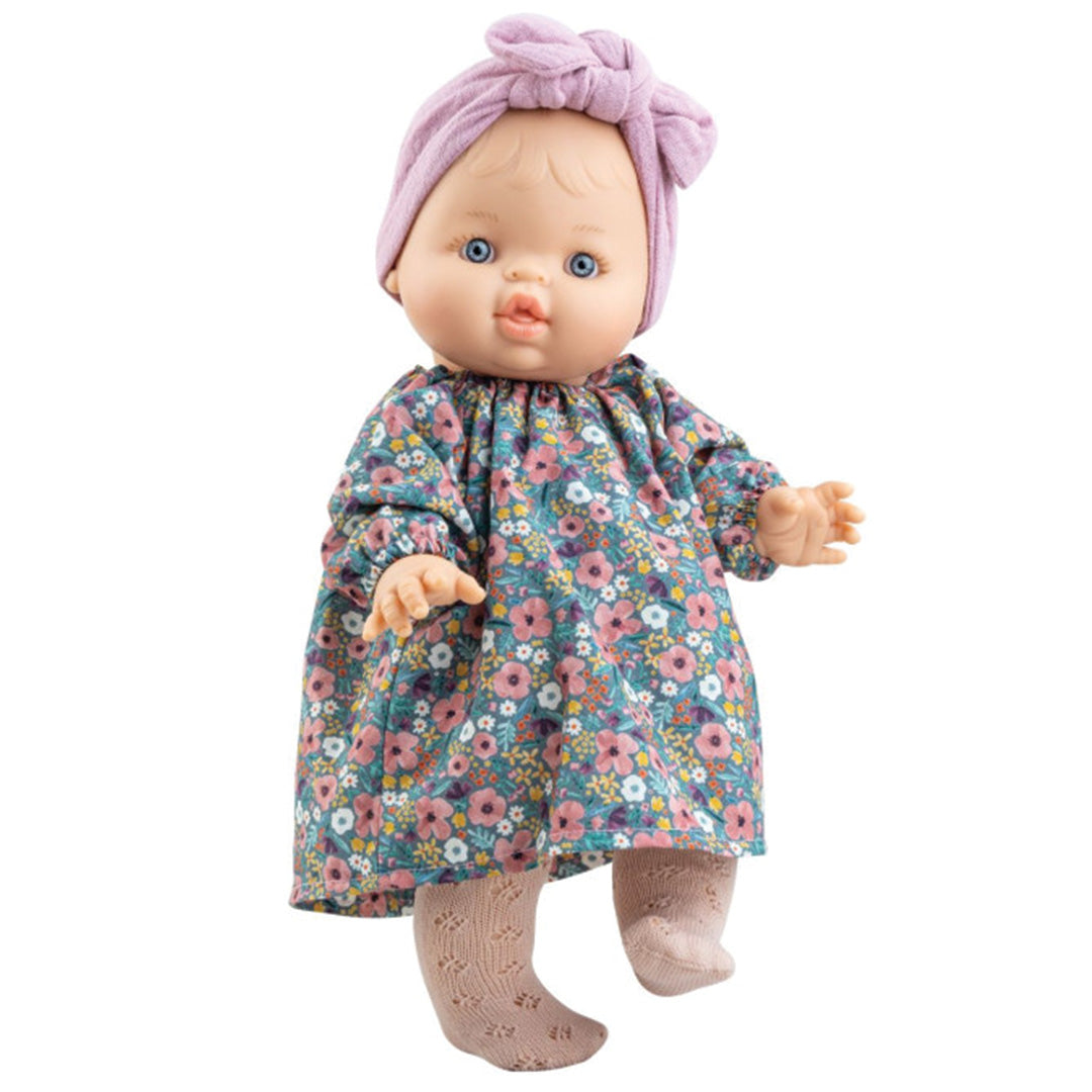Paola Reina babypop met gebloemde jurk en roze hoofdband.