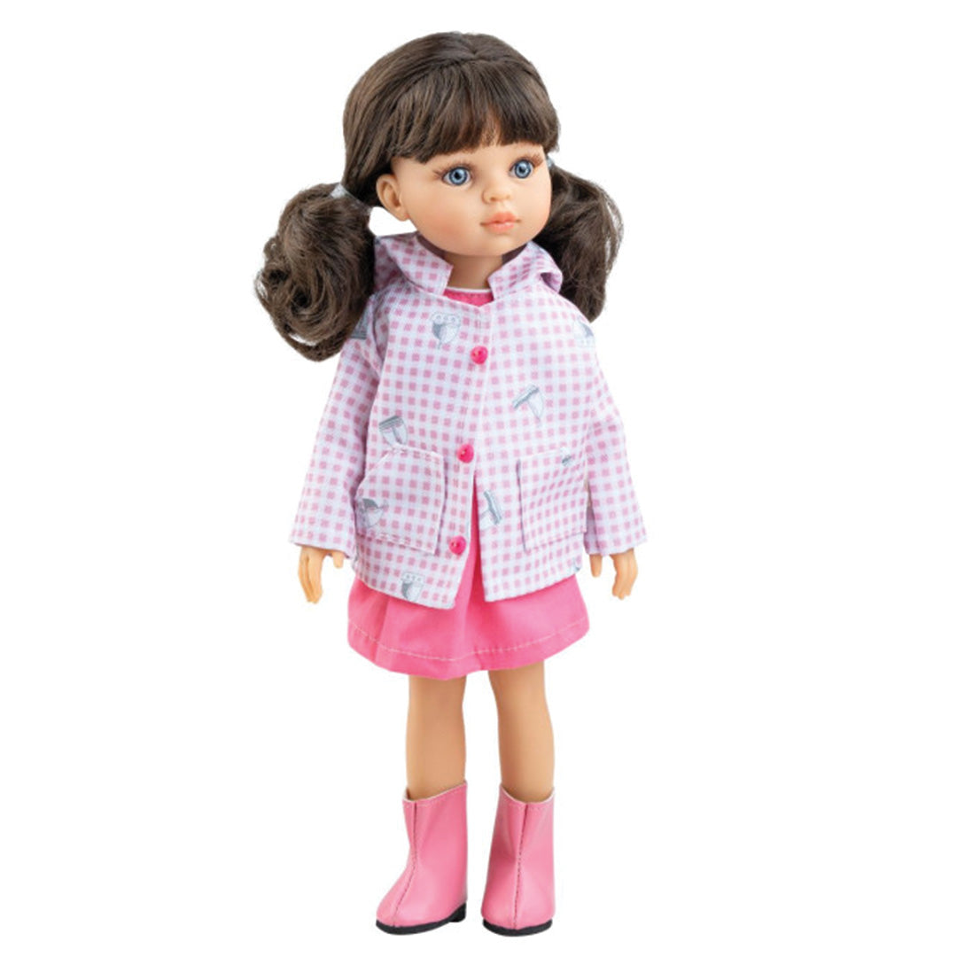 Paola Reina stapop Amigas Carol met bruine staartjes, gekleed in een roze geruite jas met voertuigpatroon, roze rok en roze laarzen.