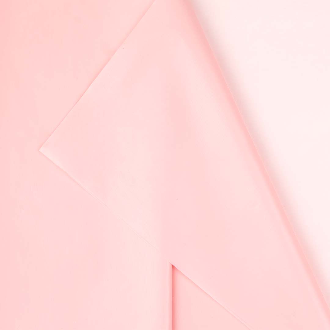 Detail van het gevouwen lichtroze plastic PartyDeco tafelkleed.