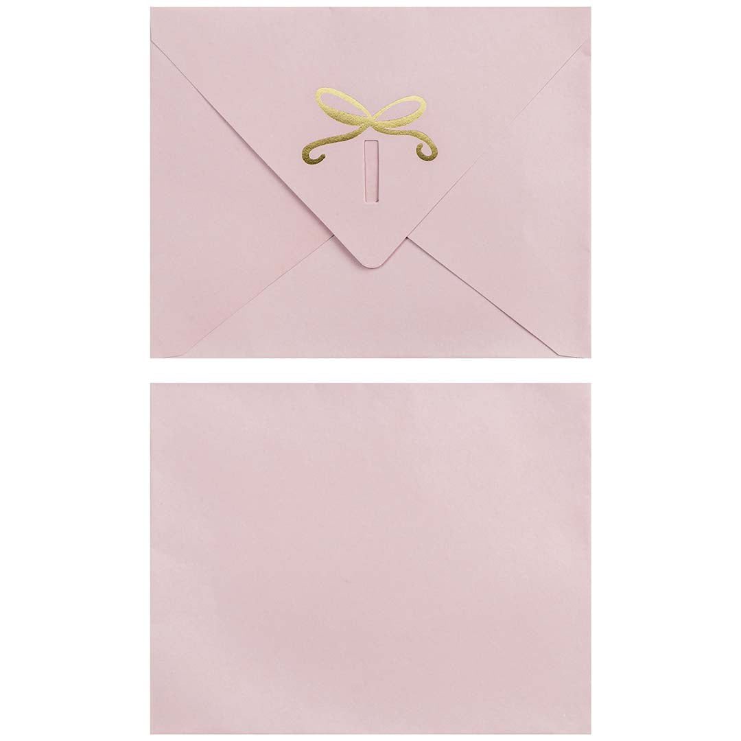 Roze envelop voor de wenskaart met een gouden strik op de achterkant.