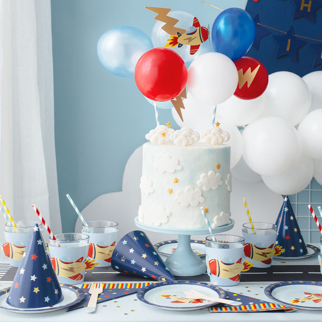 Een feestelijk gedekte tafel met diverse vliegtuigthema feestartikelen voor een verjaardag.