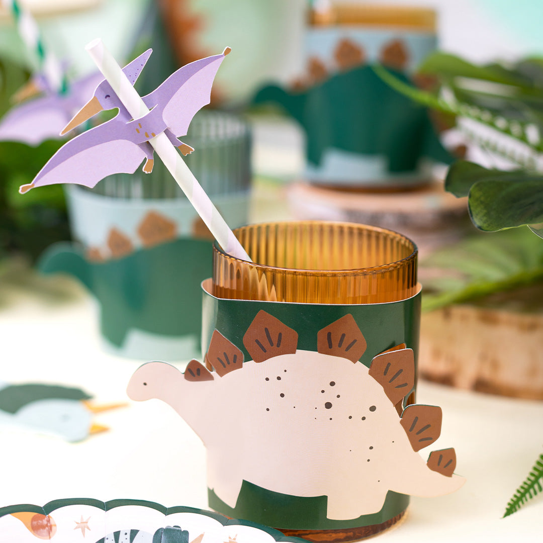 Detail van een partydeco dinosaurus bekerhoesje in beige met een rietje en pterodactyl decoratie.