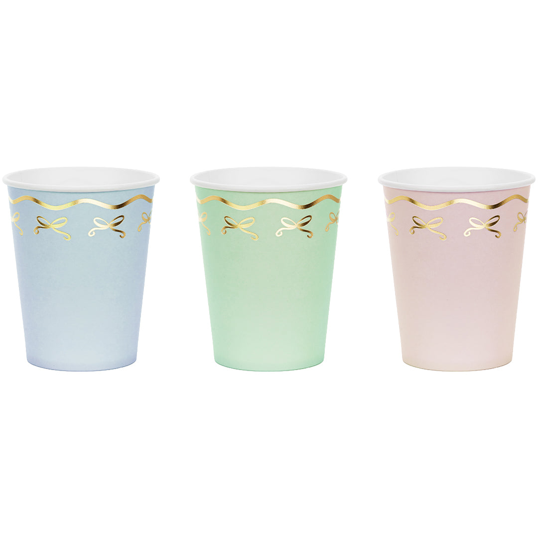 Drie Partydeco papieren feestbekers in pastelkleuren met gouden strikjes.