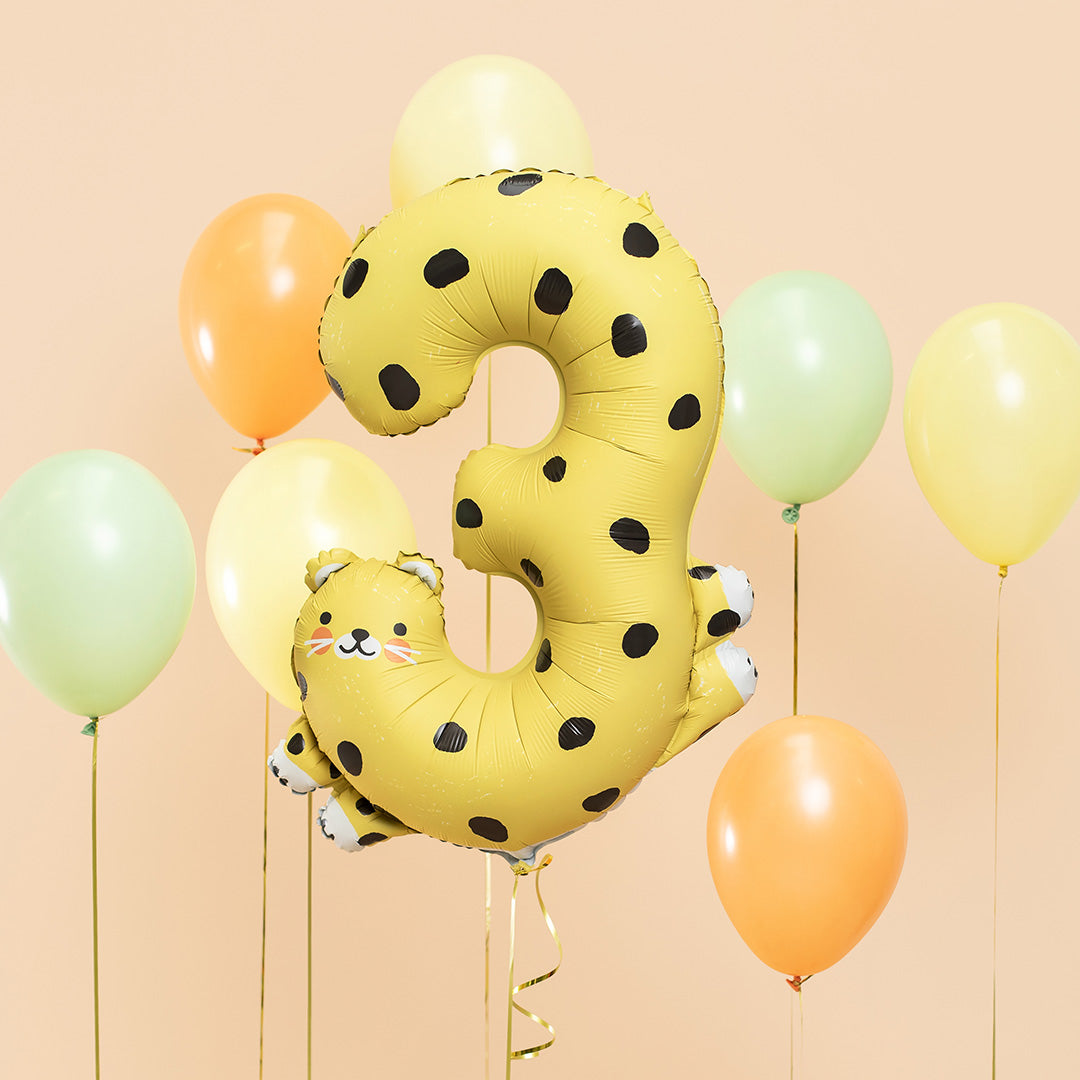De partydeco cijferballon 3 als cheetah zweeft tussen effen gele, oranje en groene ballonnen.