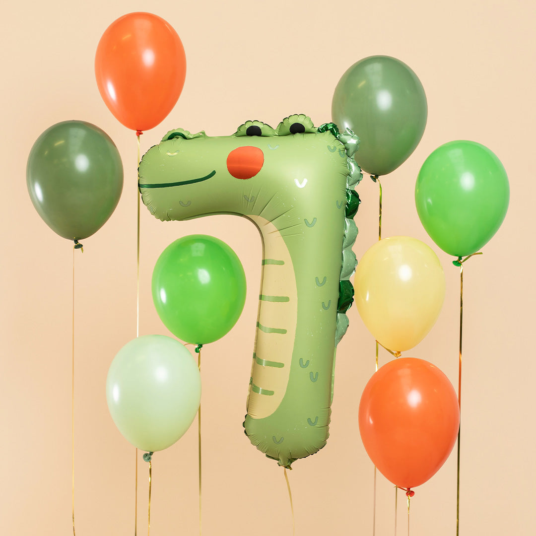 Partydeco cijferballon 7 in krokodilvorm omringd door diverse gekleurde feestballonnen.