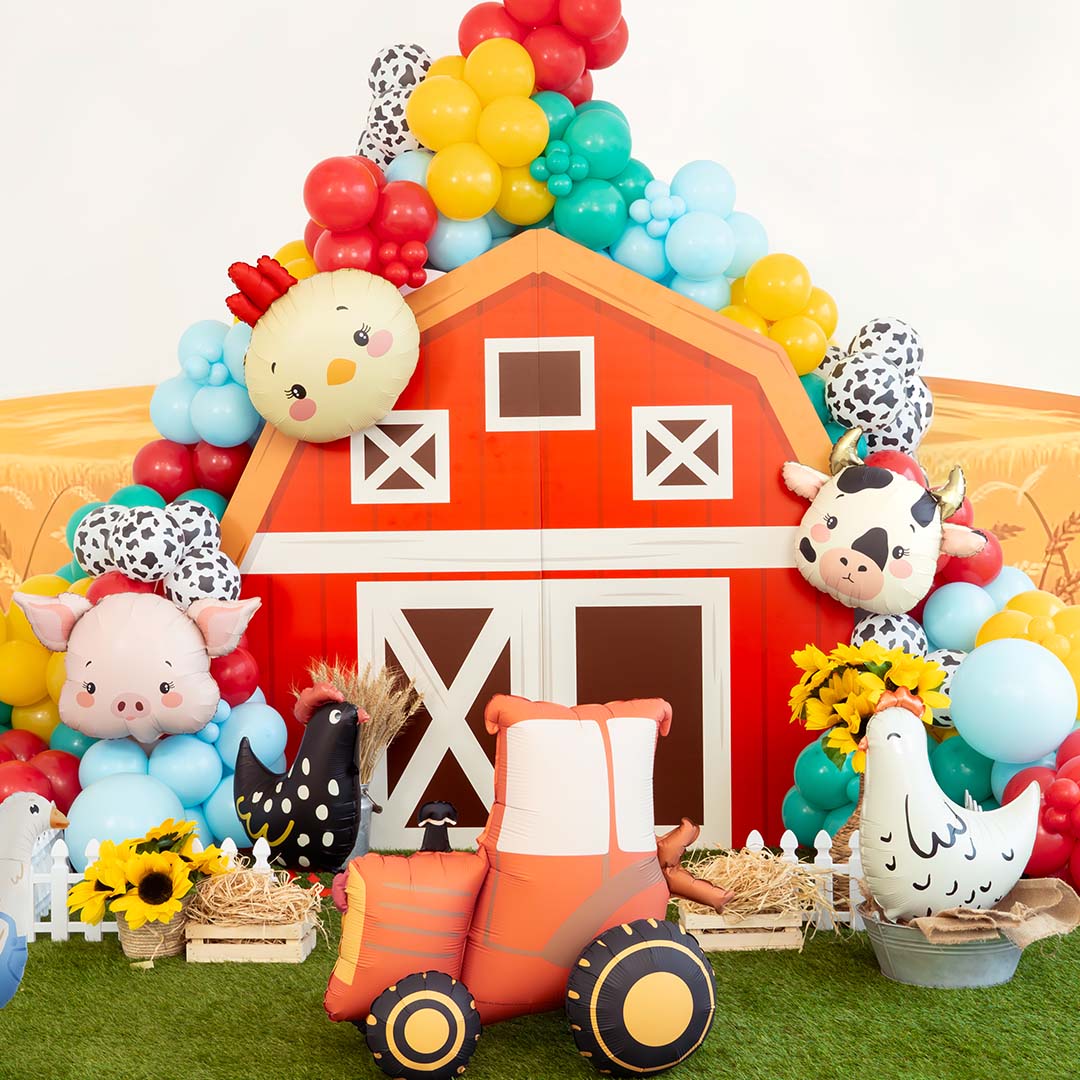 Boerderij-thema feestdecoratie met diverse folieballonnen, waaronder een kippenkop, koe en tractor.