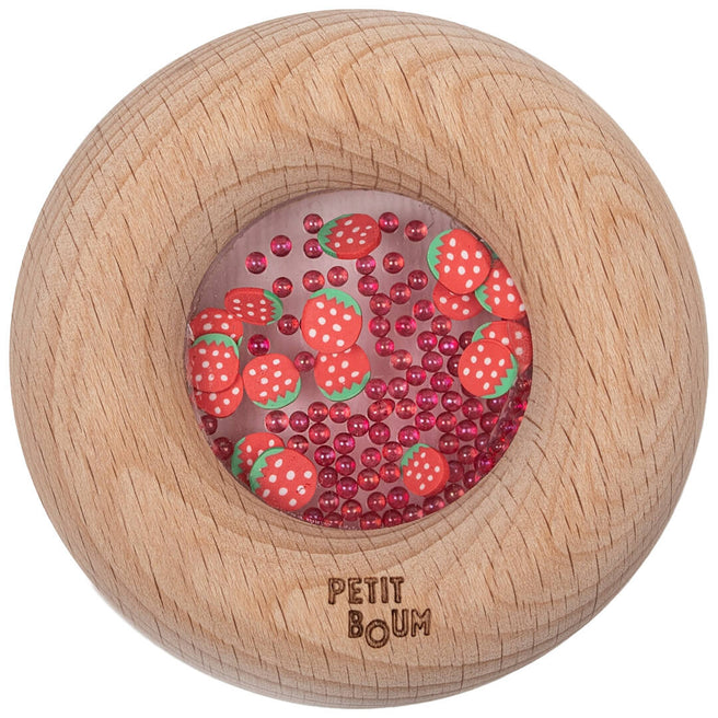 Petit Boum houten bijtring en rammelaar in de vorm van een donut met een vulling van rode aardbeien en kraaltjes.