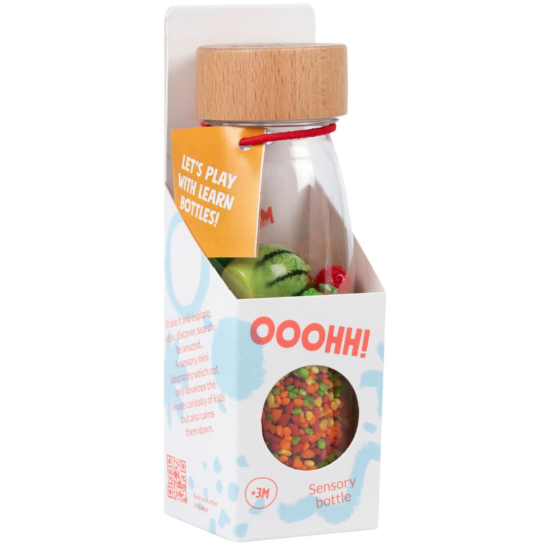 Verpakking van de Petit Boum sensorische fles met de tekst 'LET'S PLAY WITH LEARN BOTTLES!' en een doorkijkje naar de fles.