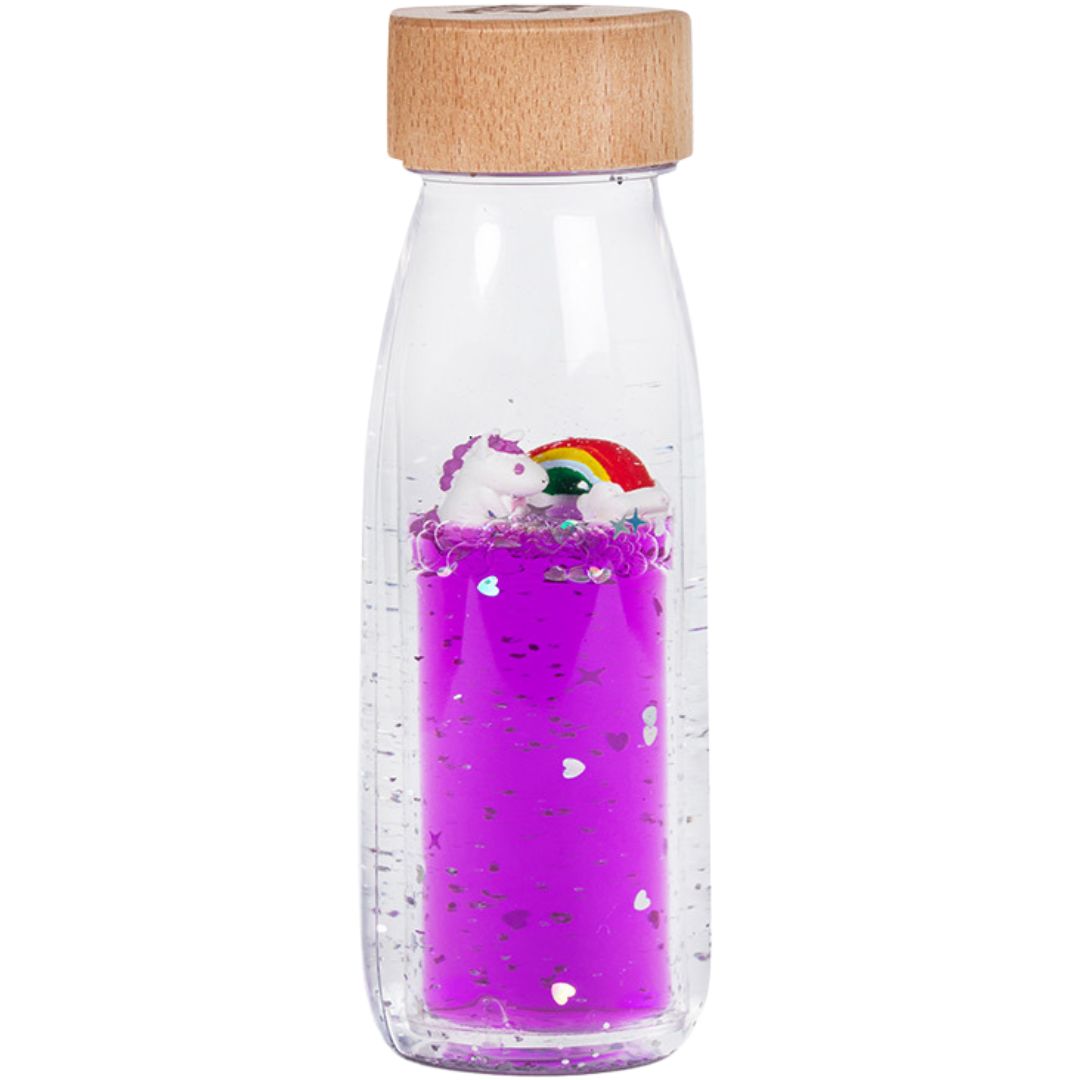 petit boum sensorische fles met paarse vloeistof, glitter, een eenhoorn en een regenboog.