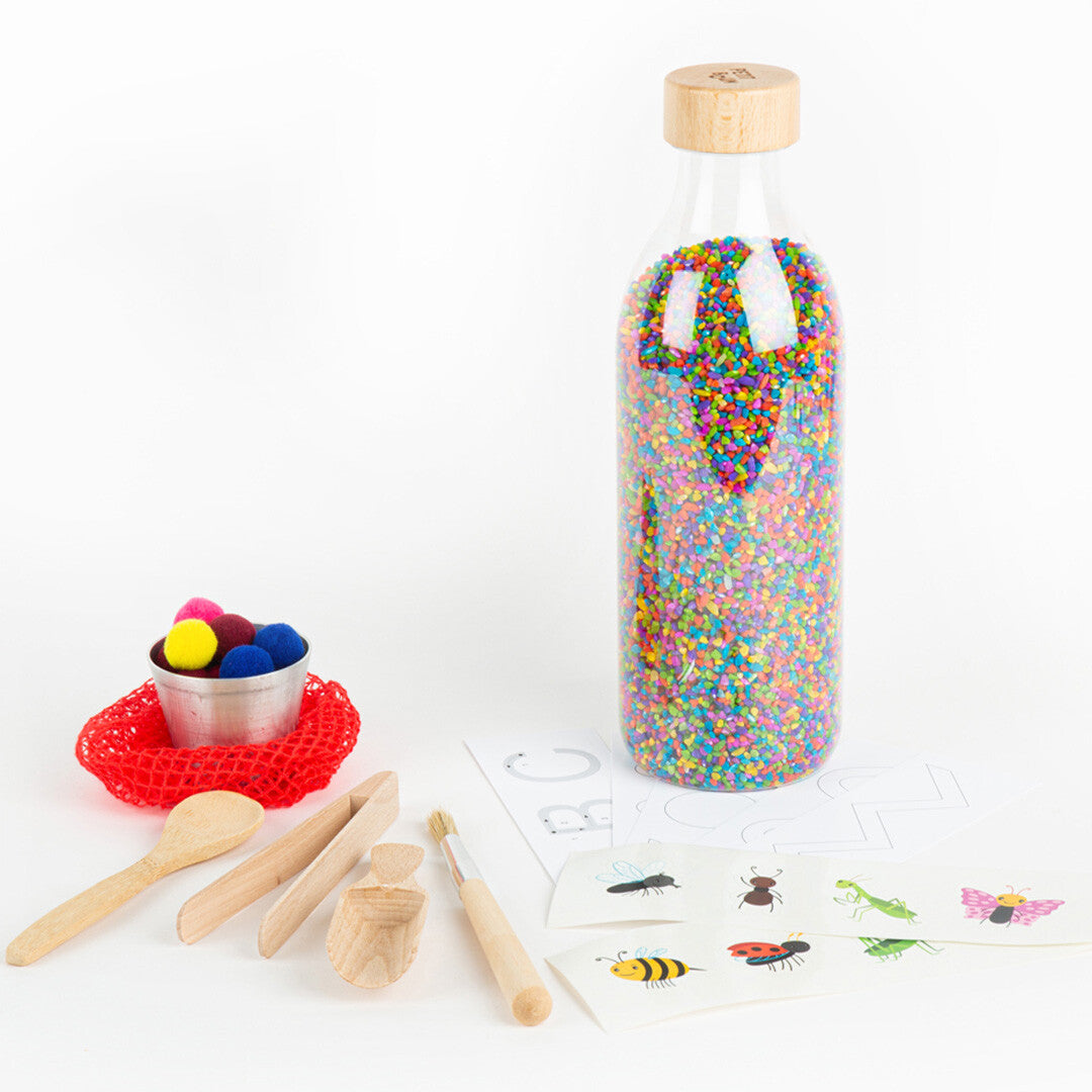 Petit Boum sensorische speelset met fles vol kleurrijke korrels, houten gereedschap, pompons en kaarten met insecten en patronen.