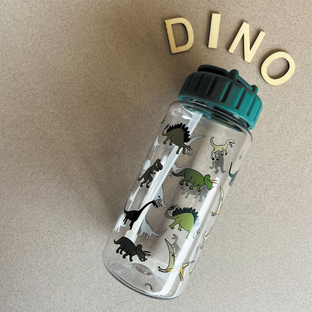 petit jour kinder drinkfles met dinosaurusprint liggend naast houten letters die 'DINO' spellen.