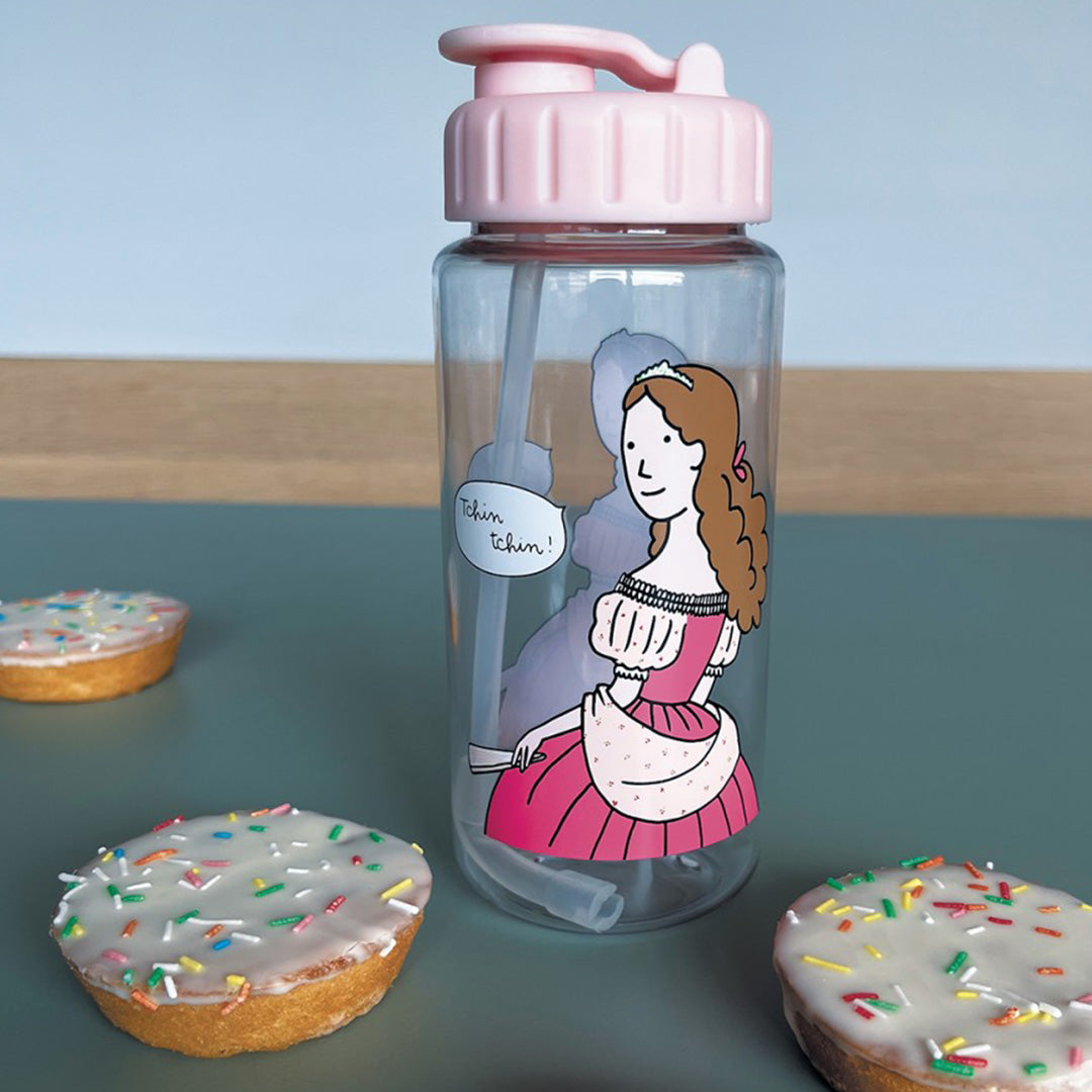 petit jour kinderdrinkfles met prinses op een tafel met drie kleine gebakjes.