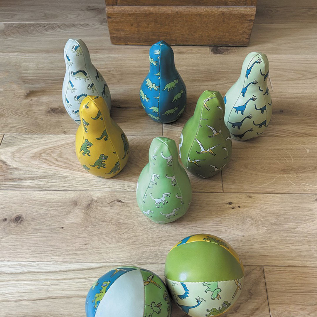 Bovenaanzicht van het dinosaurus kegelspel met kegels en ballen op een houten vloer.