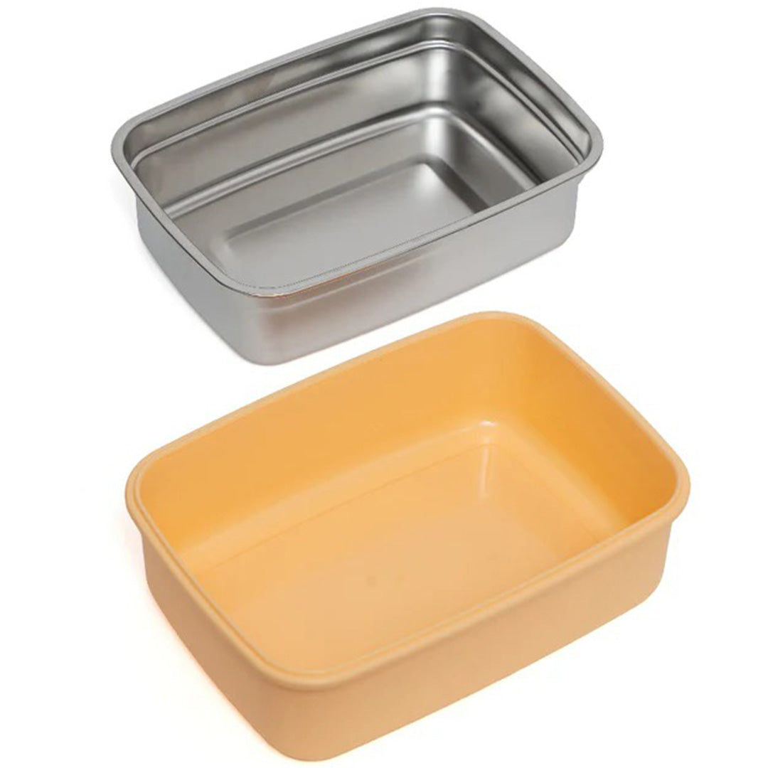 De roestvrijstalen binnenbak en de gele plastic buitenkant van de petit monkey bento broodtrommel.