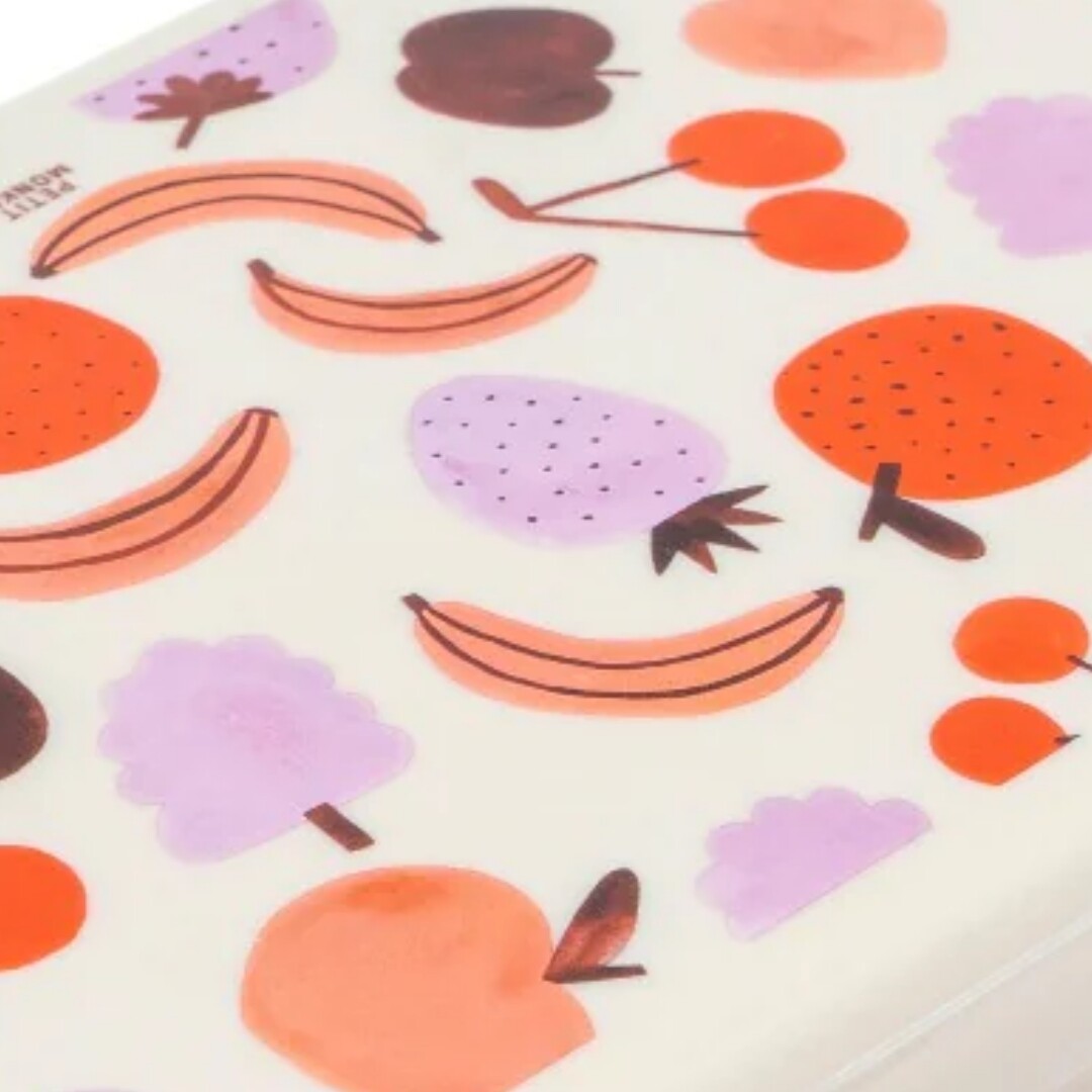Detail van de witte deksel van de Petit Monkey broodtrommel met kleurrijk fruitpatroon.