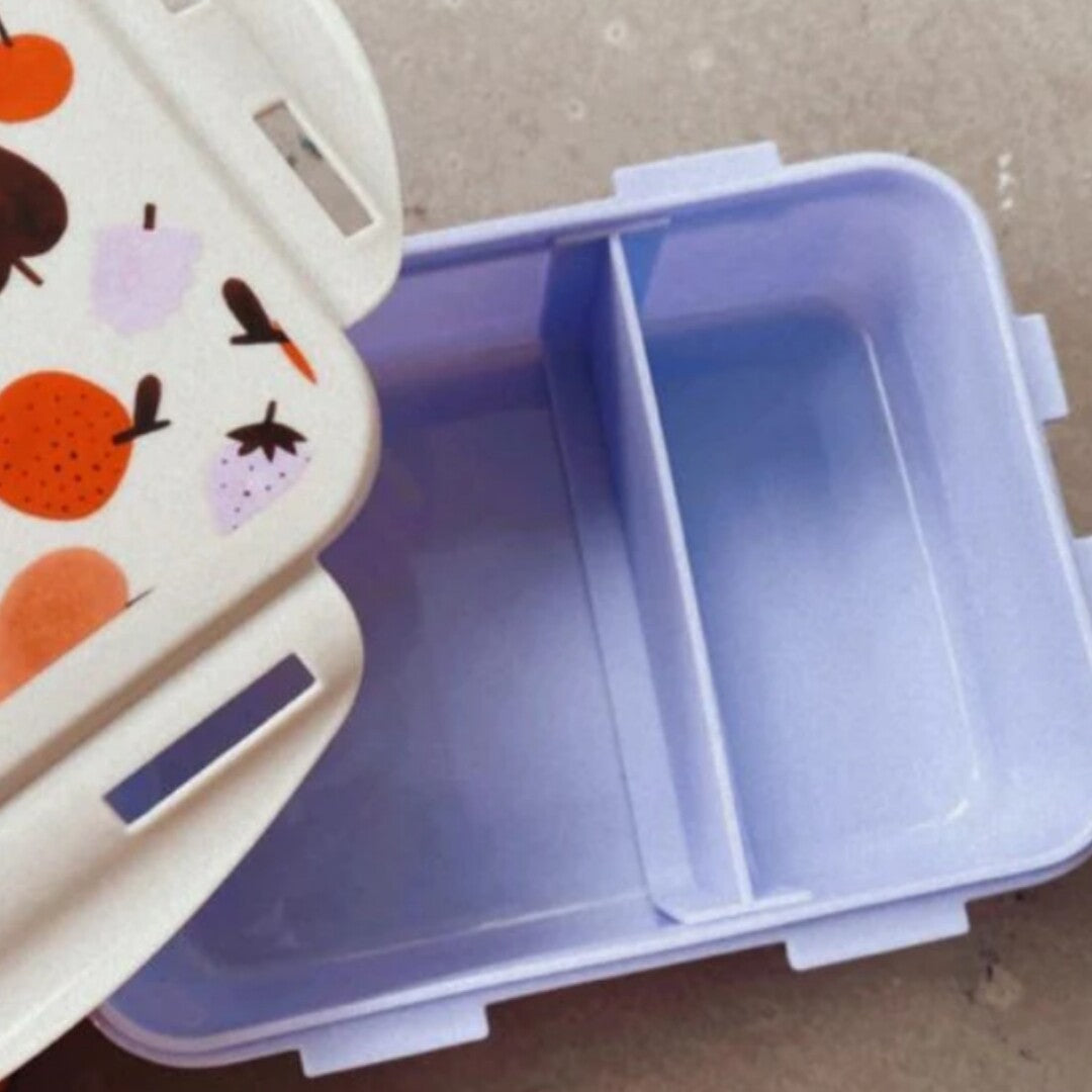 Open Petit Monkey broodtrommel met fruitpatroon op de deksel en een paarse onderkant met twee vakken.