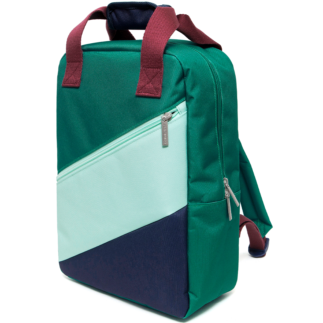 Schuine weergave van de petit monkey schoolrugzak met diagonaal patroon in groen, lichtblauw en donkerblauw.