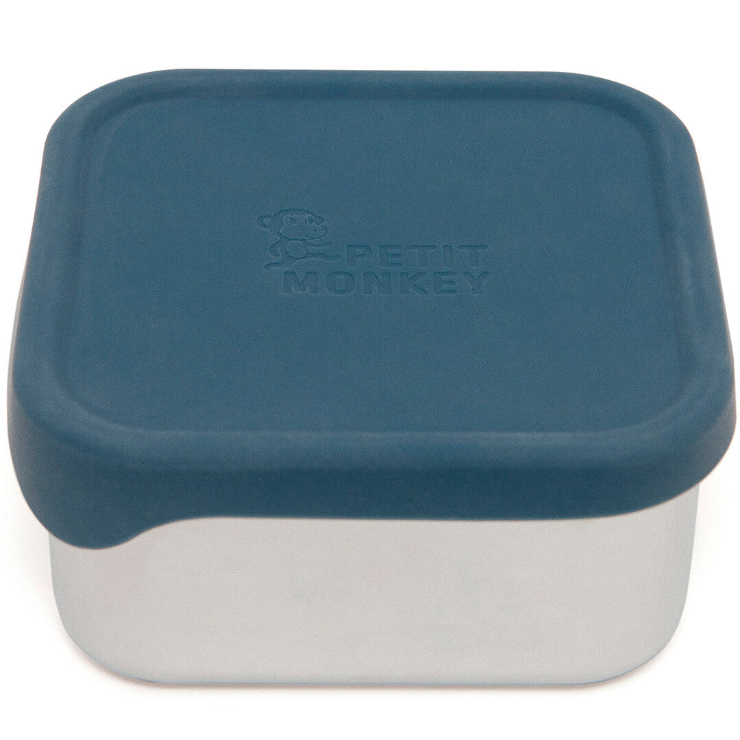 Petit Monkey RVS snackdoosje met blauw siliconen deksel en logo, schuin van bovenaf gefotografeerd.