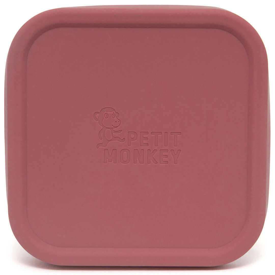 Bovenaanzicht van de roze siliconen deksel van het Petit Monkey snackdoosje met ingedrukt logo.