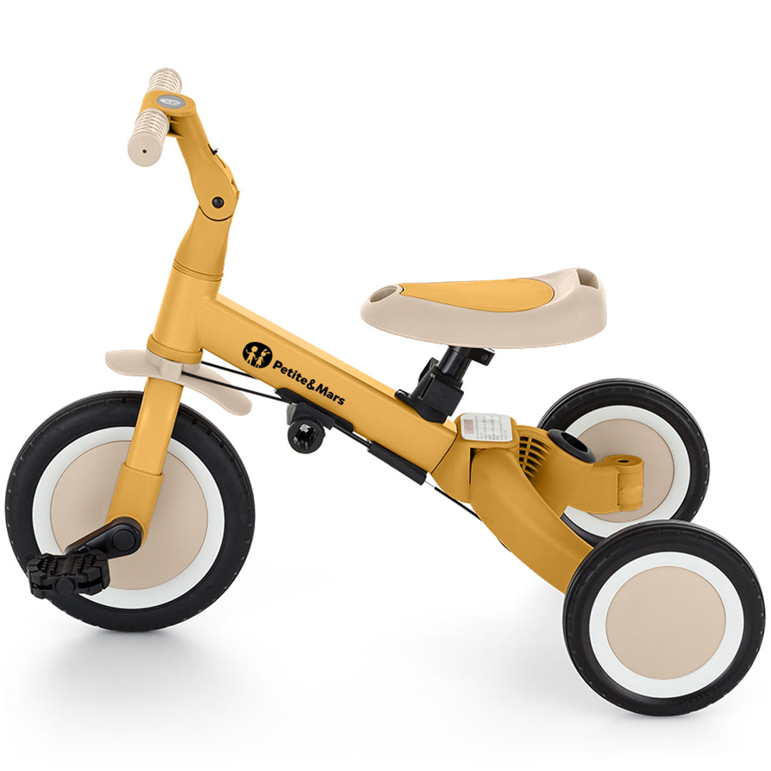 Petite&Mars 5-in-1 kinderfiets in intense ochre als driewieler met pedalen, van de zijkant.