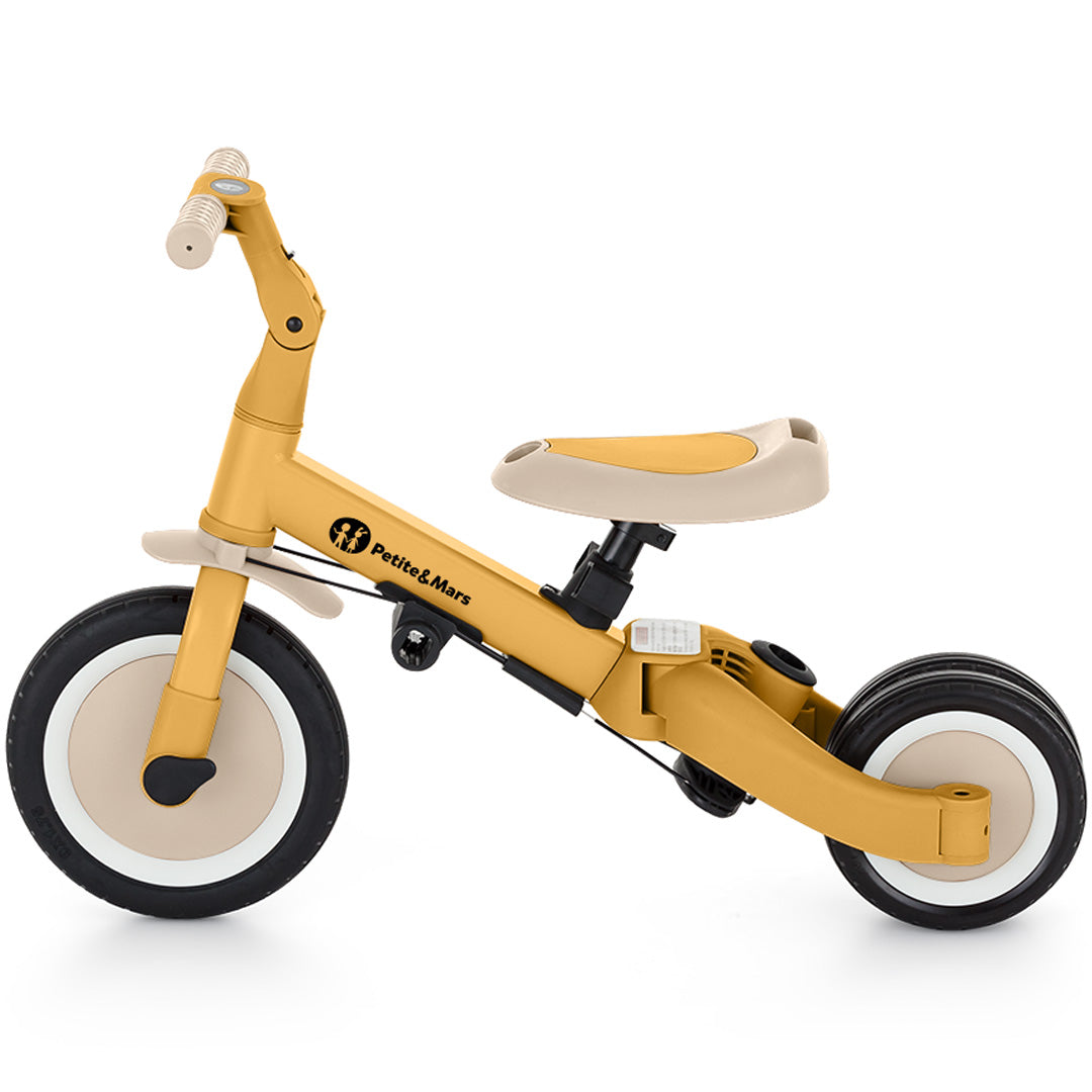 Petite&Mars 5-in-1 kinderfiets in intense ochre als loopfiets met twee achterwielen, van de zijkant.