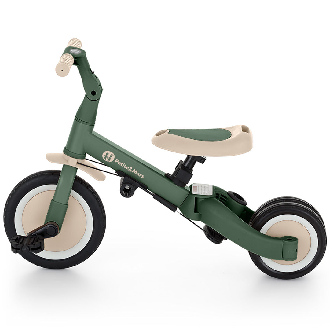 De groene Petite&Mars 5-in-1 kinderfiets in loopfietsstand met pedalen.