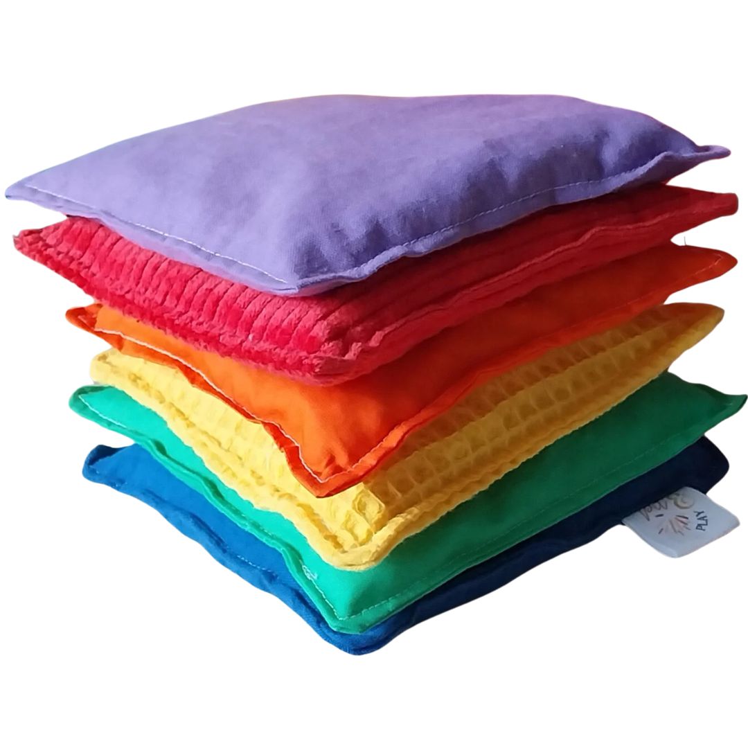 pit and play sensorische pittenzakken in regenboogkleuren, gestapeld met verschillende texturen.