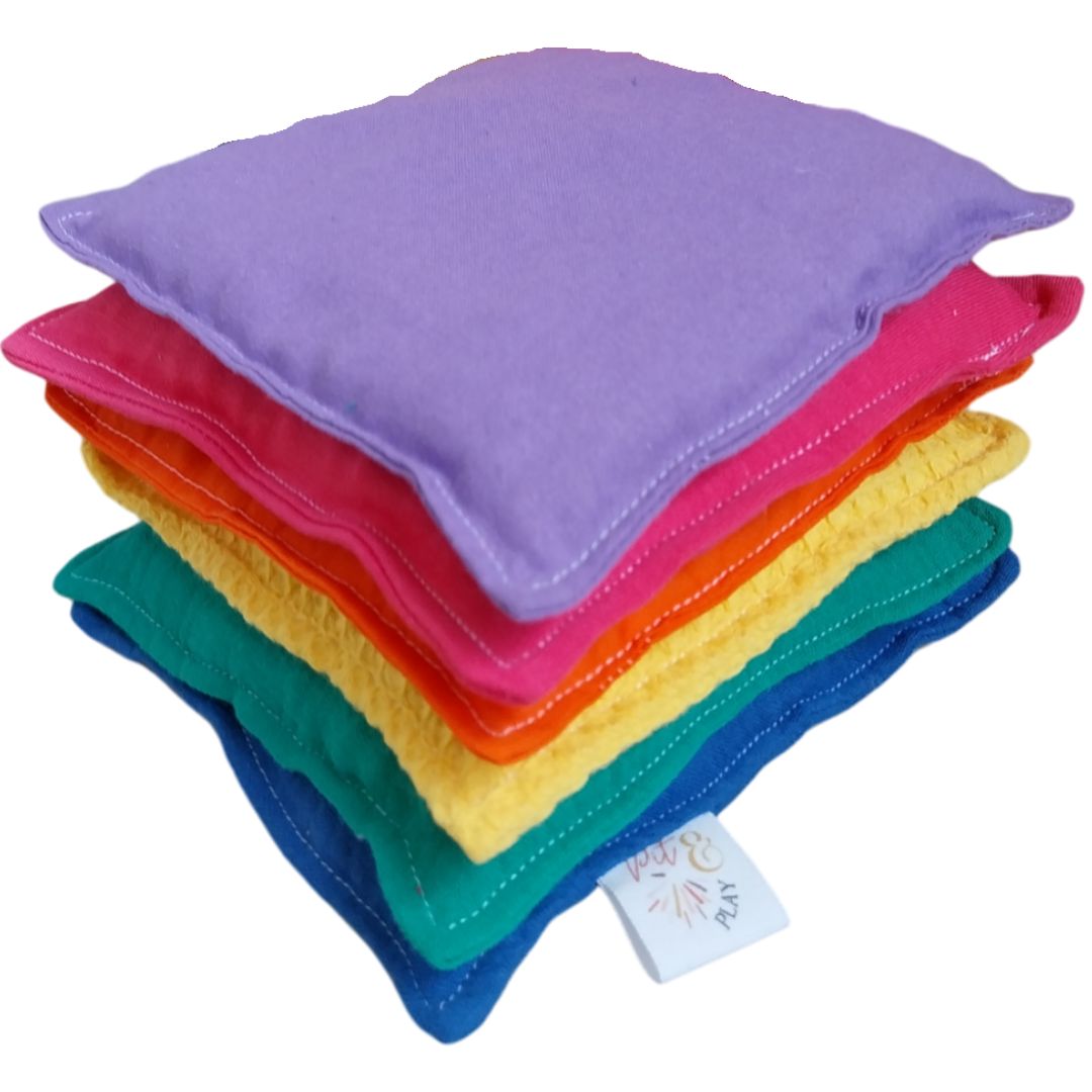 Pit & Play regenboog pittenzakken, een stapel van zes kleurrijke stoffen zakjes.