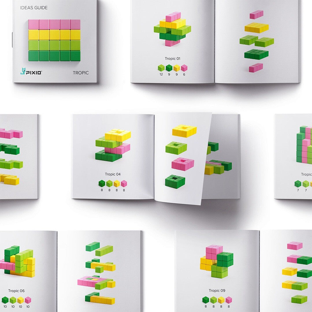 Een open Pixio 'Ideas Guide' boekje met voorbeelden van bouwwerken gemaakt met magnetische blokken in de kleuren roze, geel en groen.