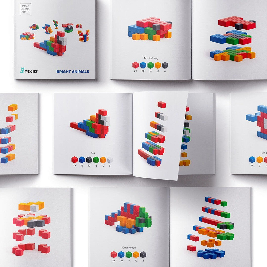Een open Pixio Ideas Guide boekje met bouwinstructies en voorbeelden van dierenfiguren gemaakt van magnetische blokjes.