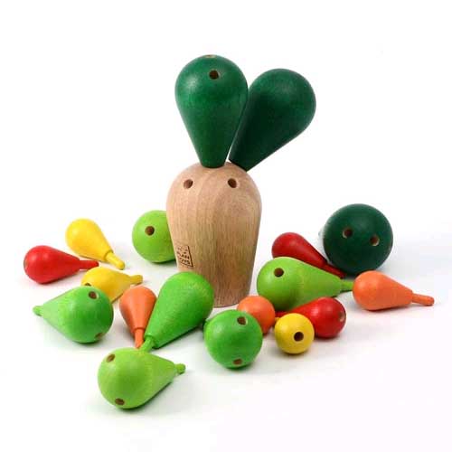 De houten basis van het Plan Toys balanceerspel cactus omringd door losse groene, rode, gele en oranje houten onderdelen.