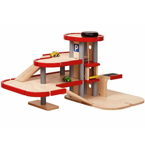 Plan Toys houten parkeergarage met twee autootjes, schuin van voren gefotografeerd.