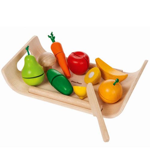 PlanToys houten speelsnijset met diverse gesneden fruit- en groentestukken en een mes op een houten dienblad.