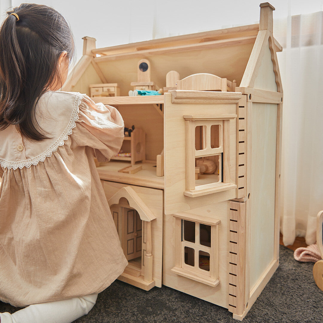 Kind speelt van achteren gezien met het Plan Toys Victoriaans houten poppenhuis.