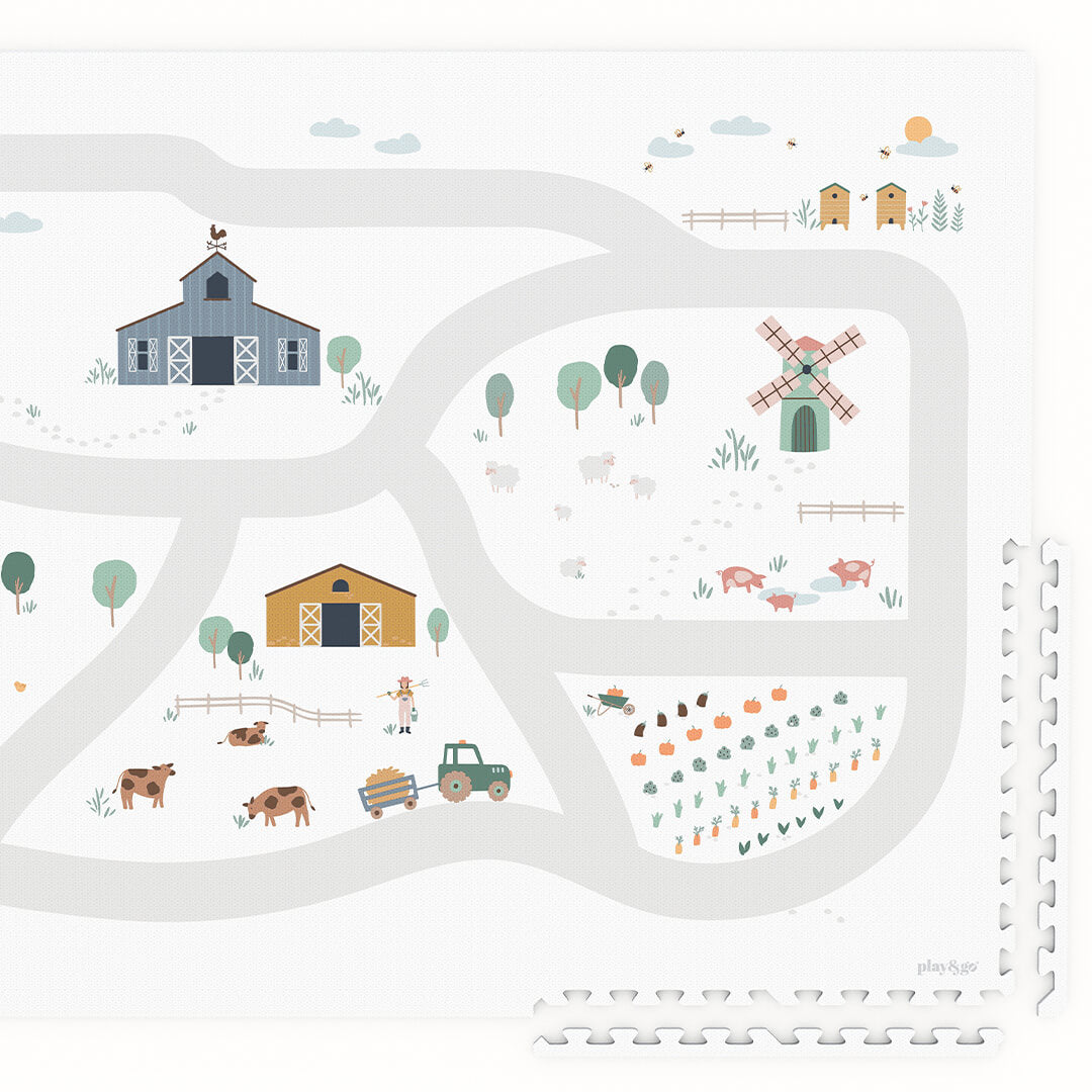 Detail van de play&go foam speelmat met boerderijthema, inclusief een schuur, windmolen en dieren.